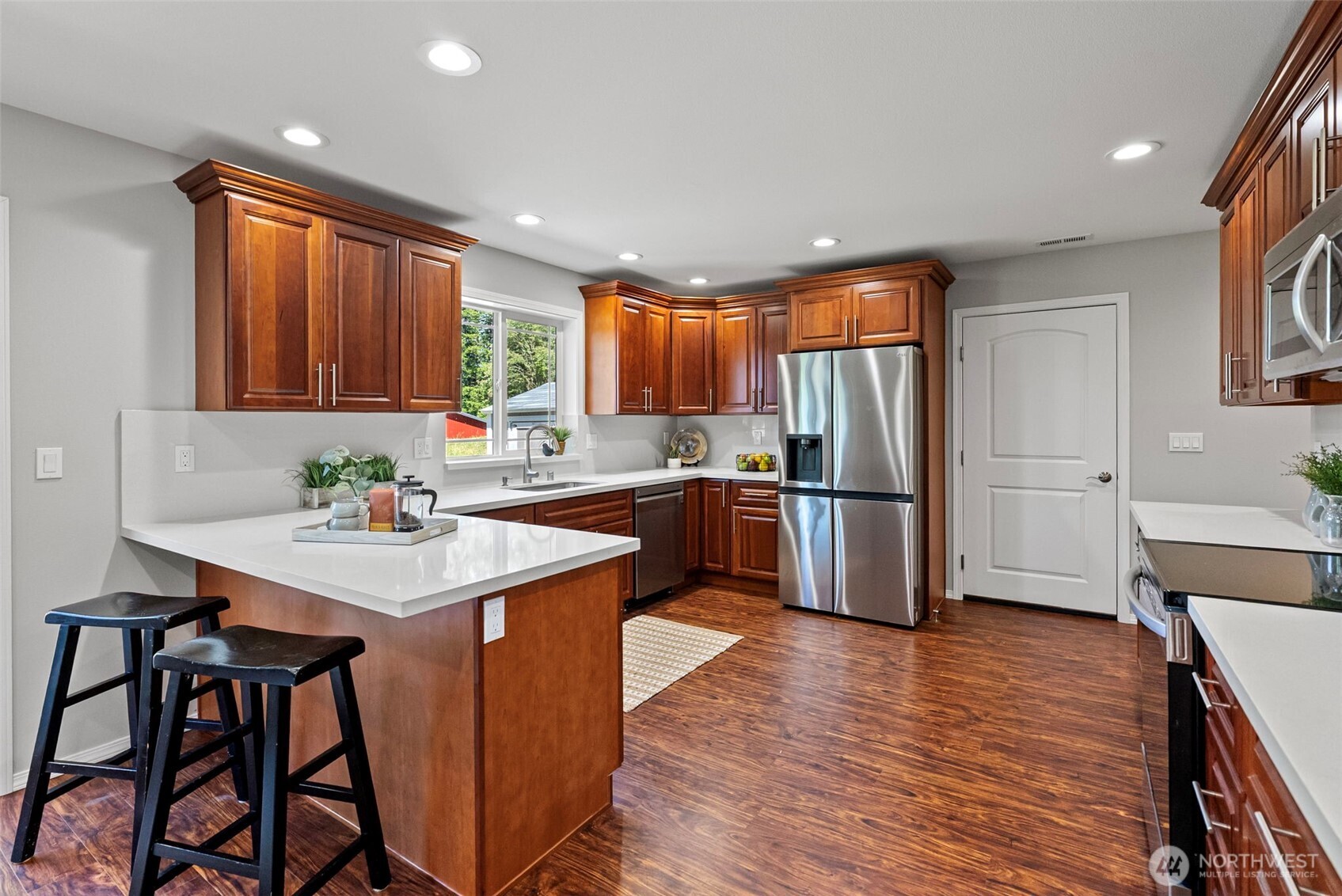 40 Northeast Eagle Crest Place Belfair, WA 98528 - Photo 7 of 27 a kitchen with stainless steel appliances granite countertop wooden cabinets a refrigerator and a stove top oven
