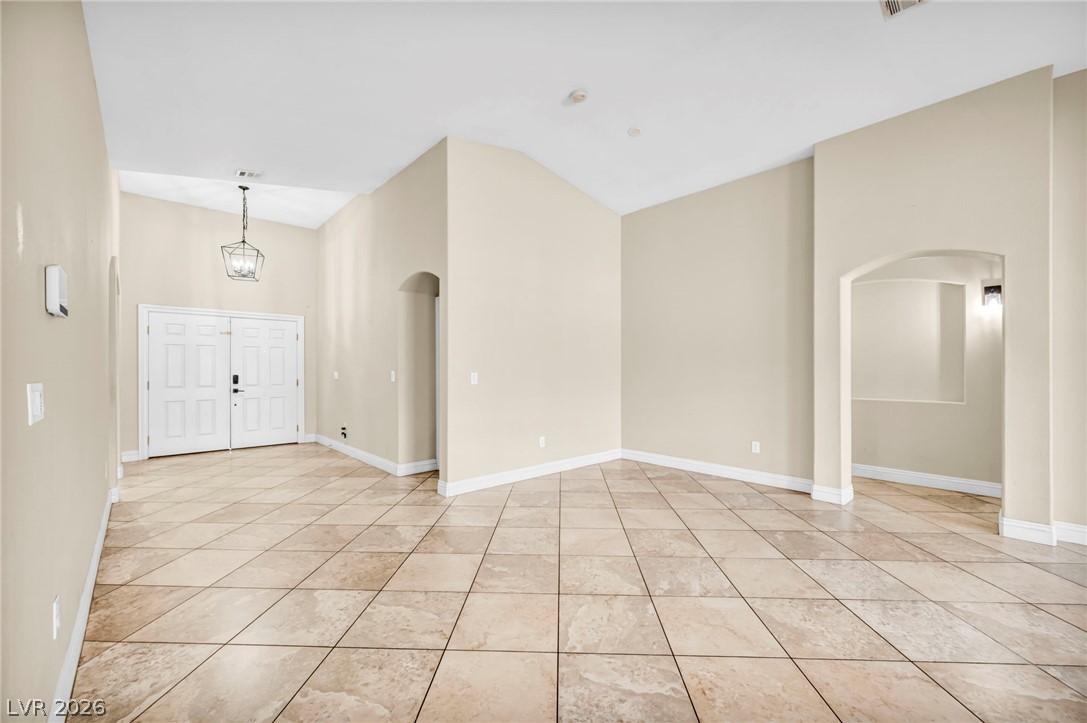 6405 North Raptor Court North Las Vegas, NV 89084 - Photo 15 of 66 A spacious foyer welcomes you into this well-lit residence, showcasing vaulted ceilings and elegant tiled floors.