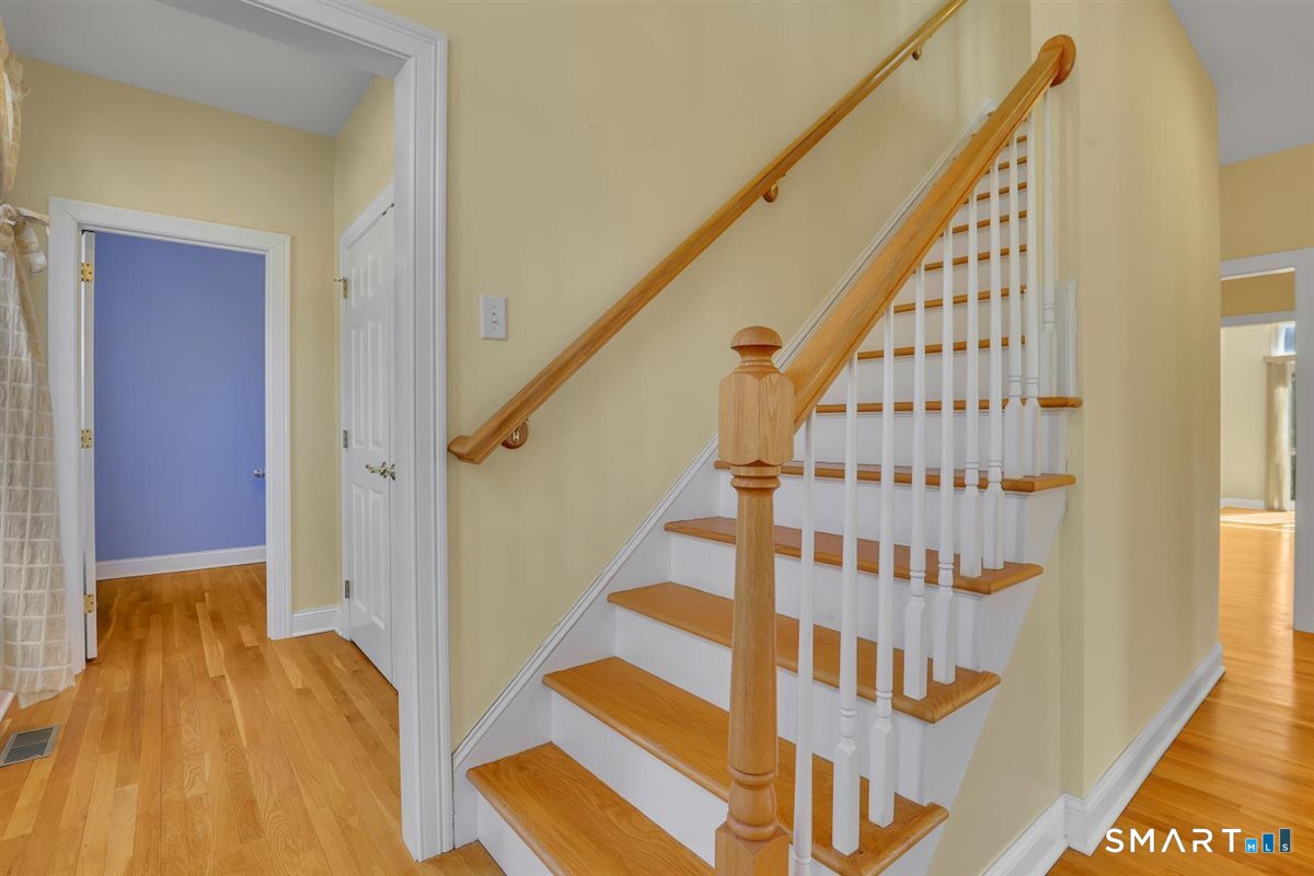 25 Fenwick Drive Avon, CT 06001 - Photo 20 of 40 a view of a hallway with wooden floor and staircase