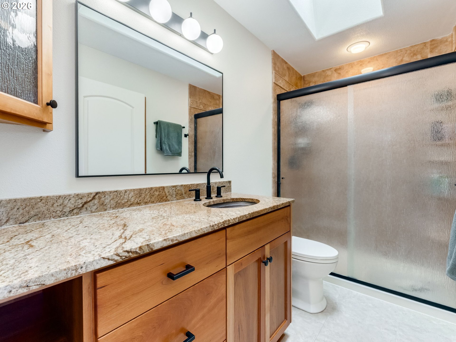 33100 Southeast Gunderson Road Boring, OR 97009 - Photo 16 of 48 a bathroom with a granite countertop sink a toilet a mirror and shower