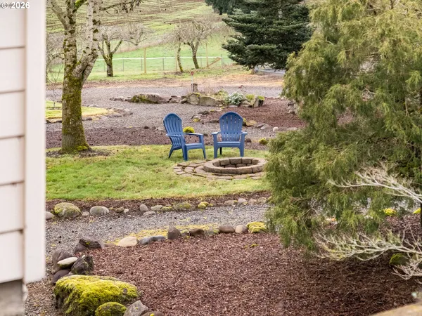 front view of a house with a small yard and a large tree