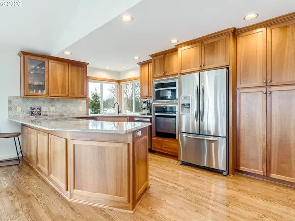 a kitchen with granite countertop a refrigerator stove top oven and sink