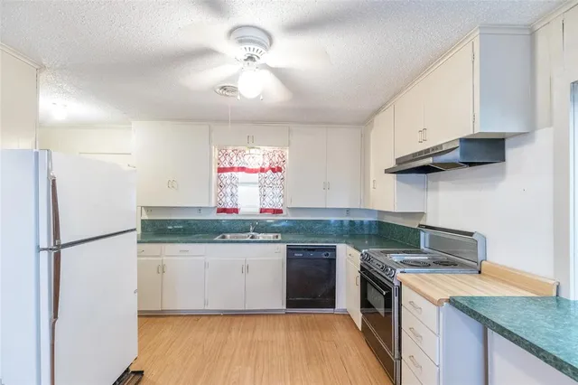 a kitchen with a sink a refrigerator and window
