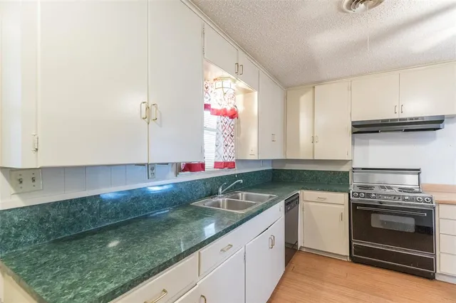 a kitchen with granite countertop a sink stainless steel appliances a counter space and cabinets