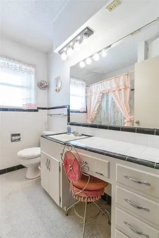 a bathroom with a sink a toilet and a mirror