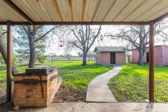 a view of a house with backyard and a tree