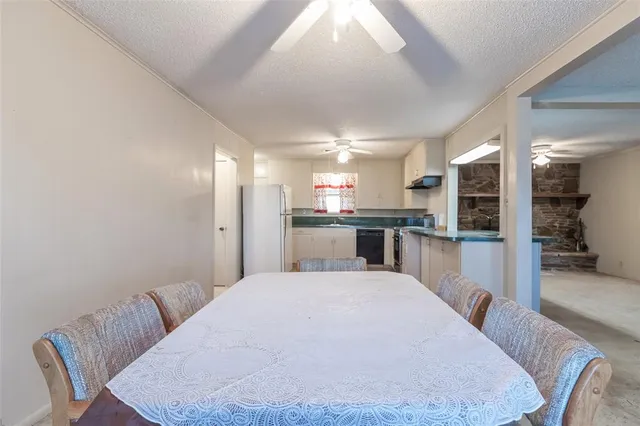 a large white kitchen with kitchen island a sink stainless steel appliances and cabinets