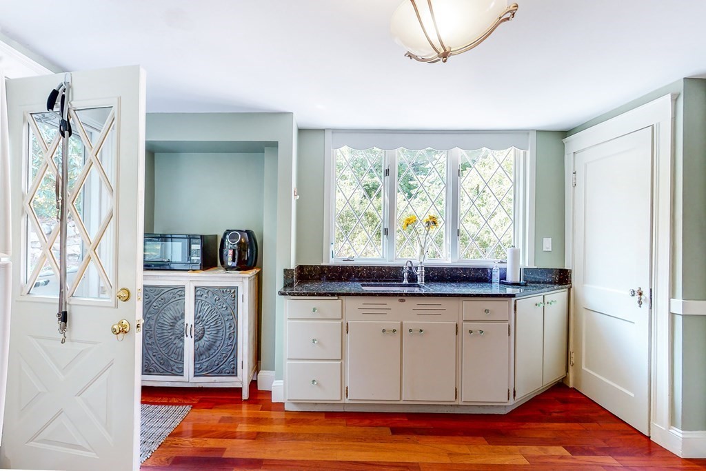 1073 Brook Road Milton, MA 02186 - Photo 6 of 30 a kitchen with granite countertop a stove a sink and a refrigerator with wooden floor