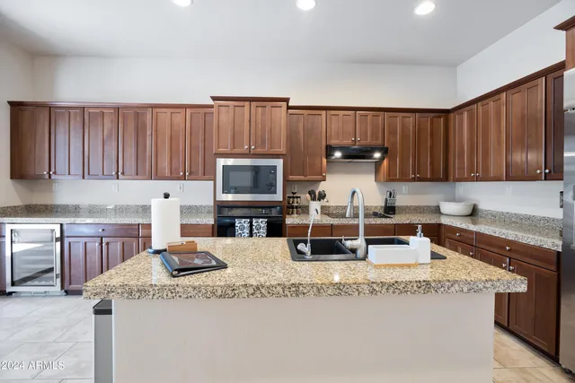 a kitchen with granite countertop a sink a stove and cabinets