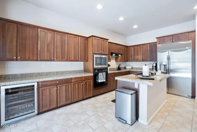 a kitchen with granite countertop wooden cabinets and white stainless steel appliances