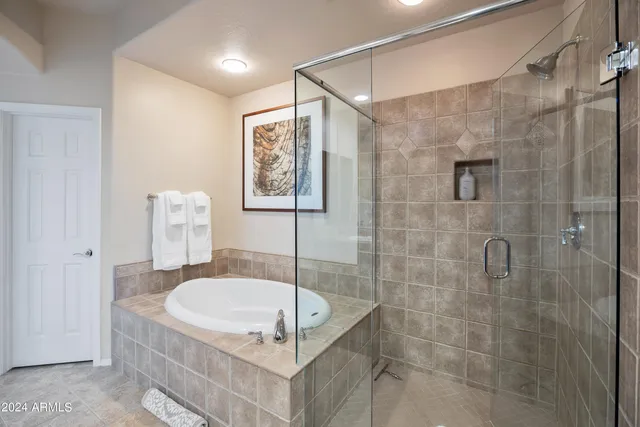 a bathroom with a granite countertop shower a sink and a mirror