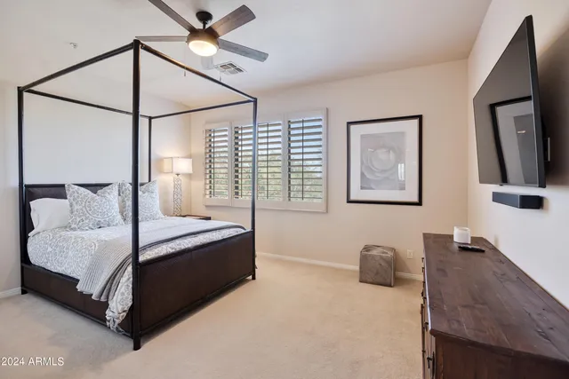 a spacious bedroom with a bed and a flat screen tv