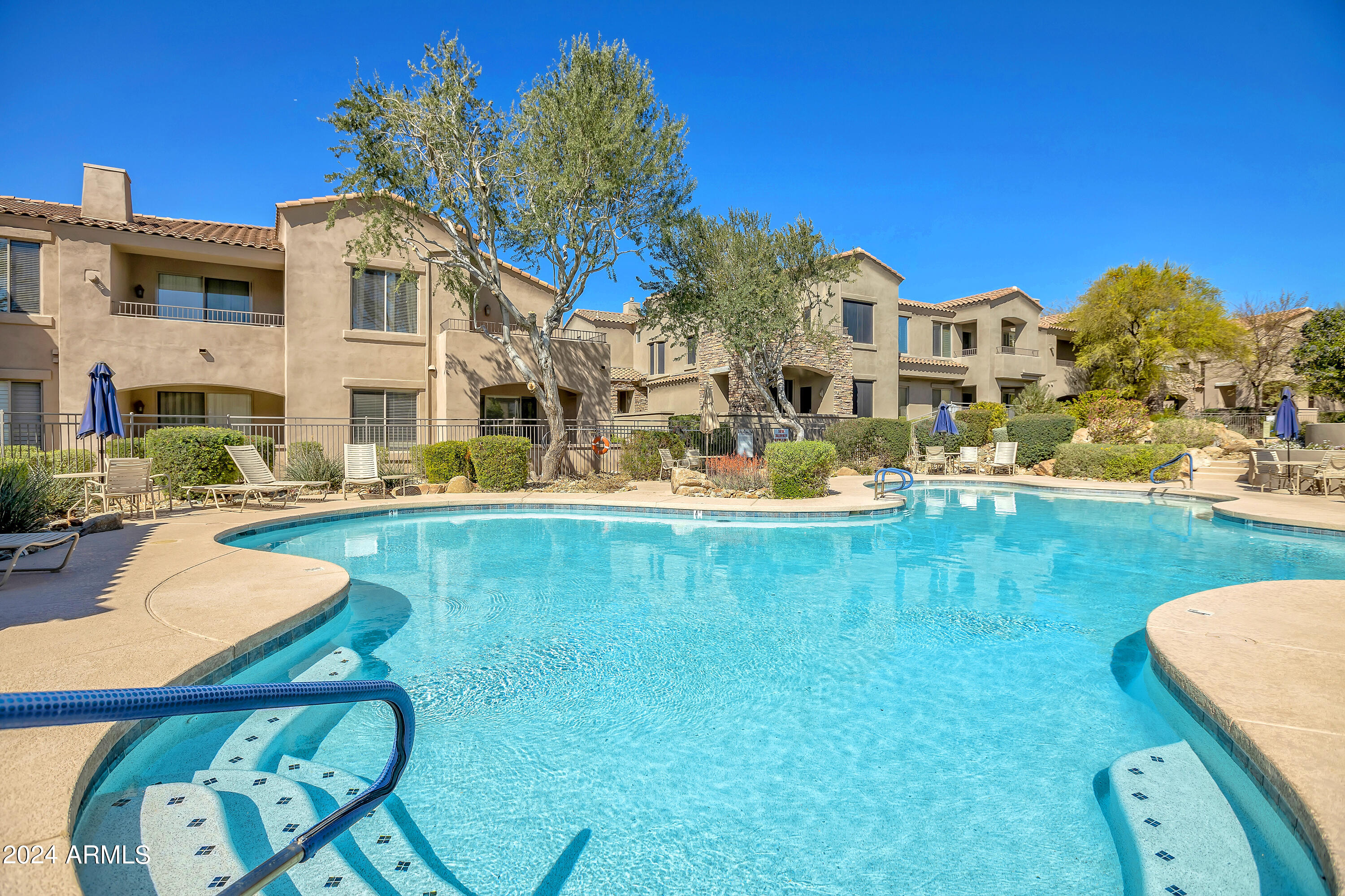 19550 North Grayhawk Drive, Unit 1137 Scottsdale, AZ 85255 - Photo 46 of 48 a front view of a house with swimming pool having outdoor seating
