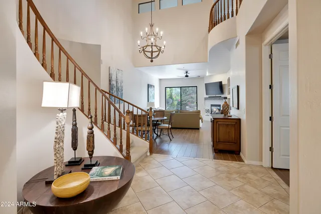 a view of a livingroom with furniture a fireplace a chandelier and wooden floor