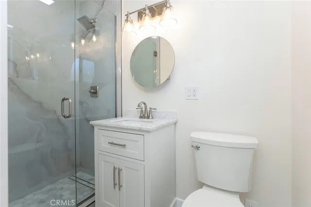 a bathroom with a toilet sink vanity and mirror