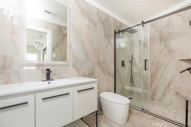 a bathroom with a sink toilet a mirror and shower