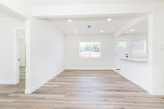 an empty room with wooden floor and a window