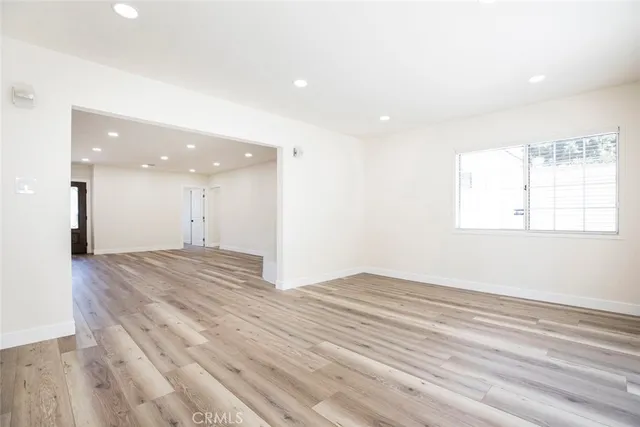 an empty room with wooden floor and a window