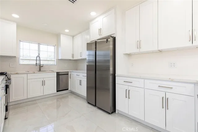 a kitchen with white cabinets and white stainless steel appliances