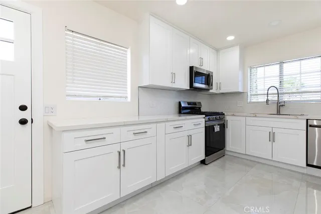 a kitchen with white cabinets and a stove