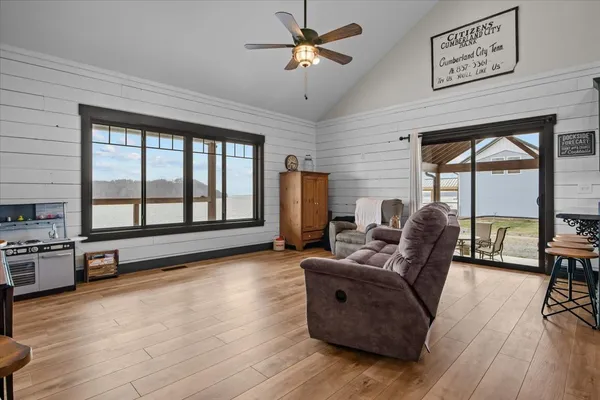 a living room with furniture large window and wooden floor