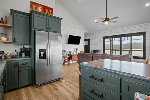 a kitchen with stainless steel appliances granite countertop a refrigerator a stove and a sink with wooden floor