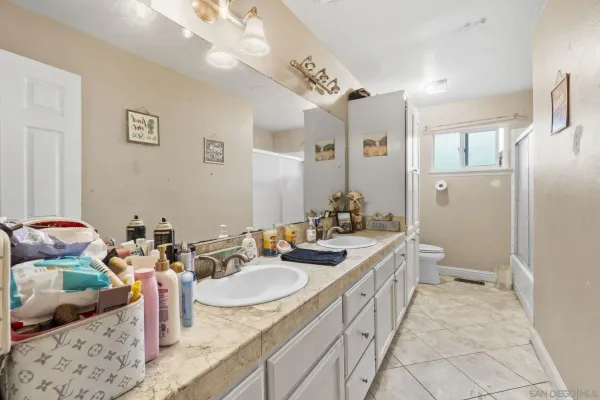 a spacious bathroom with a granite countertop sink a mirror and a shower