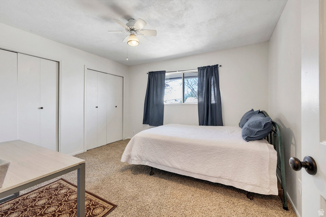 3334 Ute Road St. George, UT 84790 - Photo 15 of 40 Bedroom with two closets, carpet floors, ceiling fan, and a textured ceiling