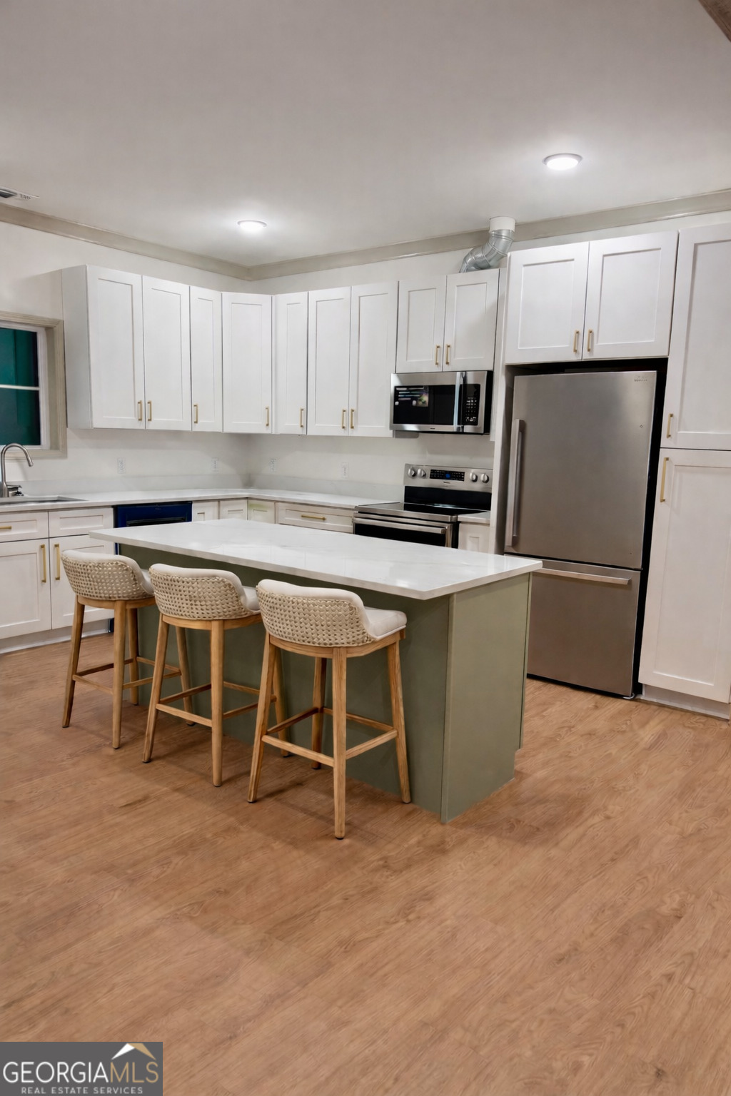 1337 Wildflower Circle Metter, GA 30439 - Photo 5 of 13 a kitchen with stainless steel appliances granite countertop a stove top oven a sink a dining table and chairs