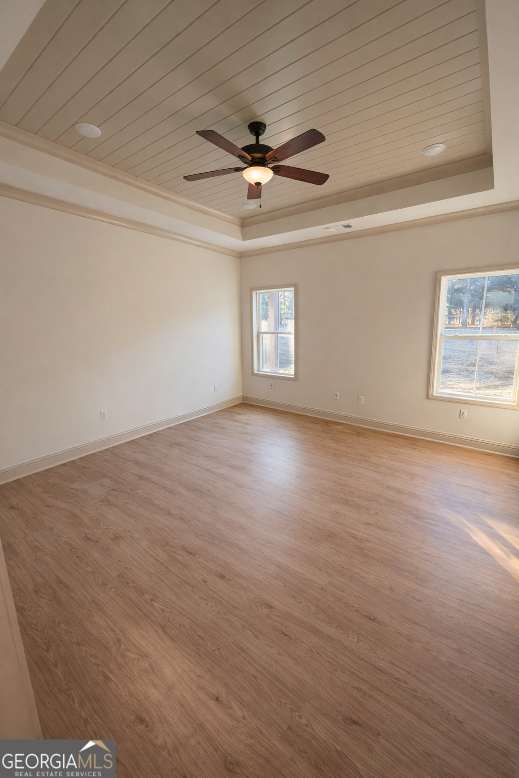 1337 Wildflower Circle Metter, GA 30439 - Photo 7 of 13 an empty room with wooden floor a ceiling fan and windows