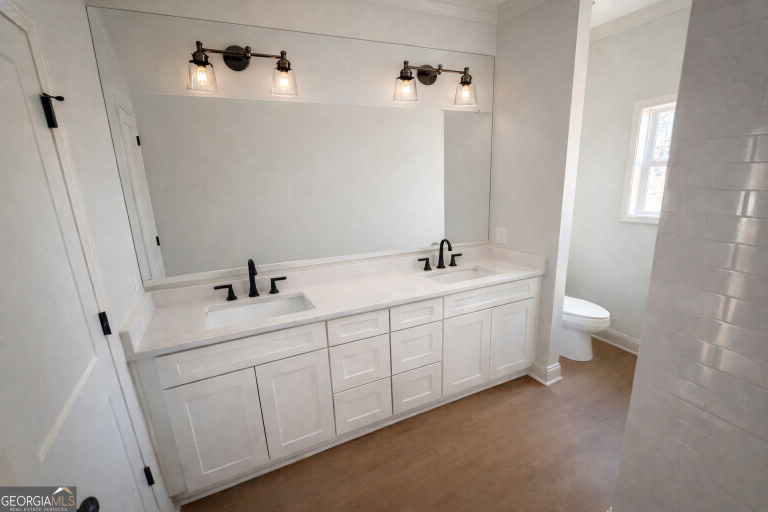 1337 Wildflower Circle Metter, GA 30439 - Photo 8 of 13 a bathroom with a double vanity sink and mirror with toilet
