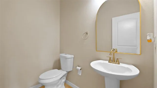 a bathroom with a sink toilet and a mirror