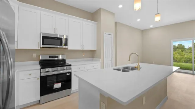 a kitchen with granite countertop a stove top oven a sink a counter space and cabinets