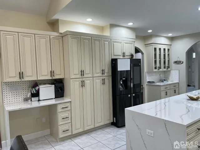 a kitchen with stainless steel appliances kitchen island granite countertop a refrigerator and a sink