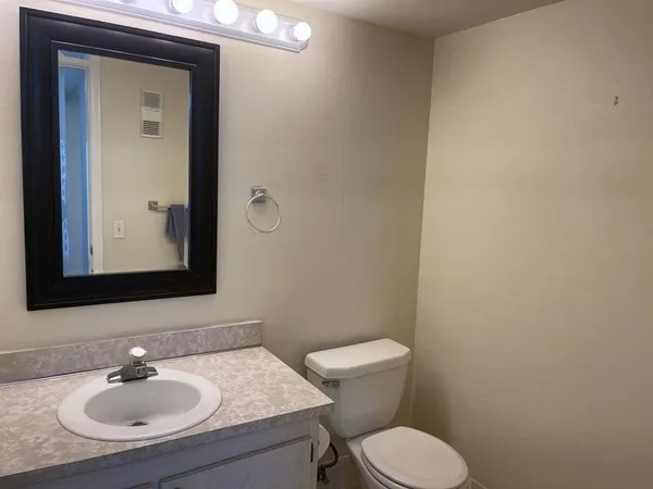 a bathroom with a toilet a sink and mirror