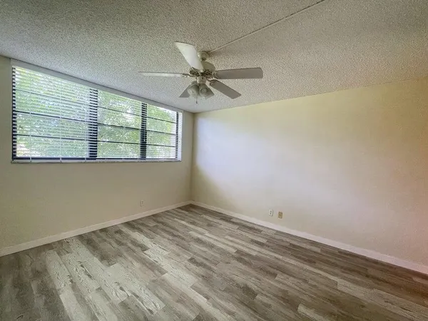 an empty room with a window and a fan