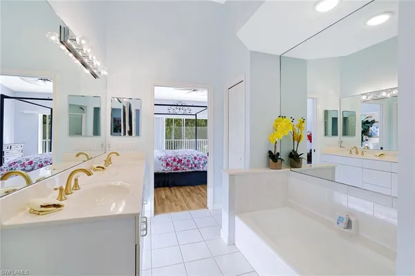a bathroom with a tub sink and mirror