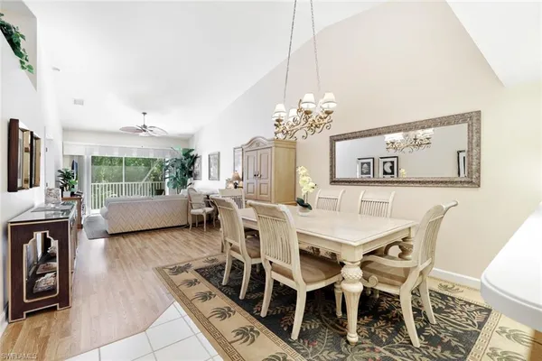 a view of a dining room with furniture a chandelier and wooden floor