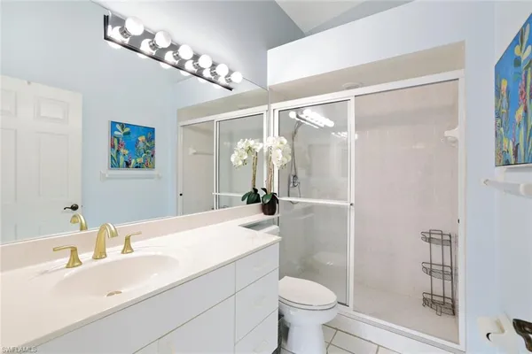 a bathroom with a sink a toilet a mirror and shower