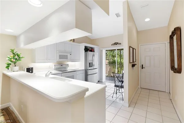 a kitchen with a sink a refrigerator and cabinets