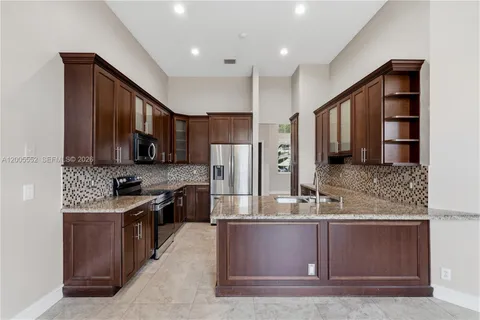 a kitchen with granite countertop stainless steel appliances and a refrigerator