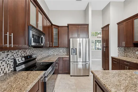 a kitchen with a granite countertop sink and cabinets