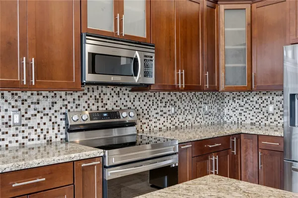 a kitchen with stainless steel appliances granite countertop a sink stove and refrigerator
