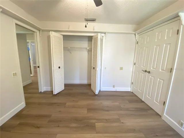 a view of a hallway with wooden floor and a cabinet