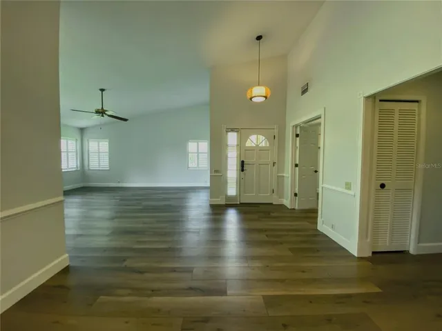 a view of empty room with wooden floor and windows