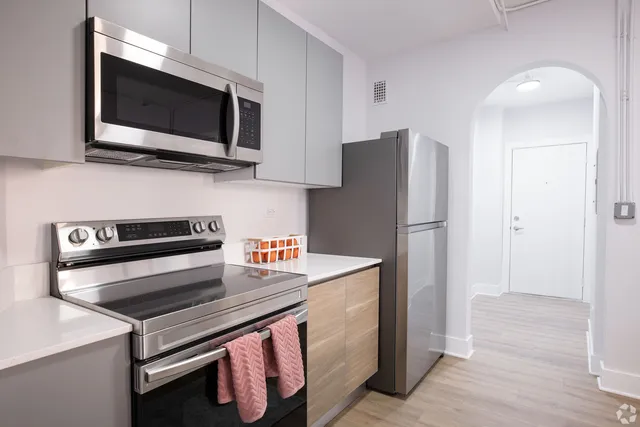 a kitchen with stainless steel appliances a stove microwave and refrigerator