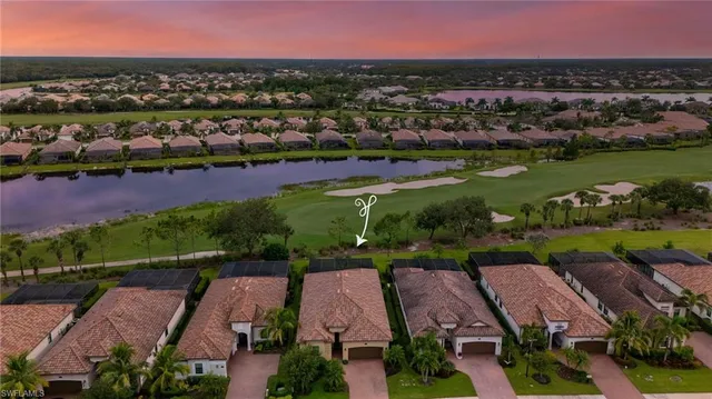 an aerial view of residential houses with outdoor space and lake view