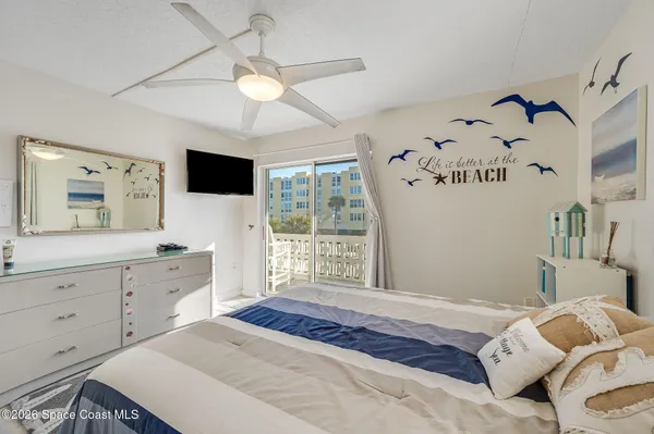a bedroom with a large bed and a flat tv screen on dresser