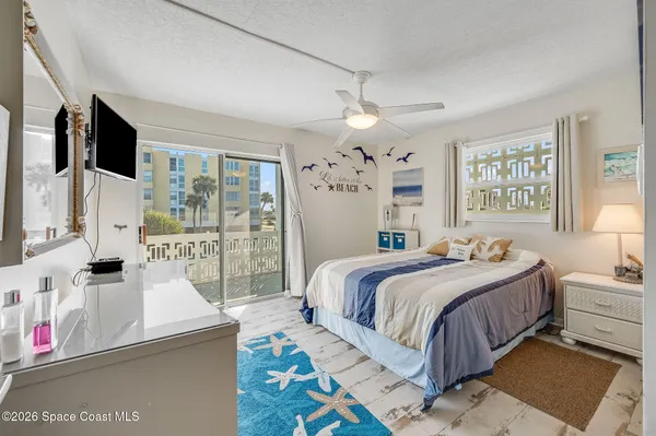 a bedroom with a bed next to a large window with the view of bedroom