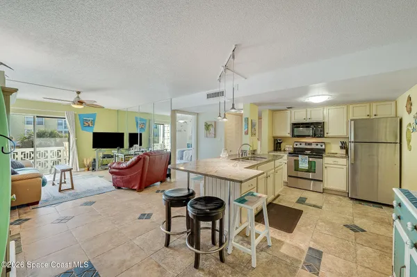 a large kitchen with a table chairs stainless steel appliances and cabinets
